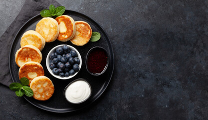 Cottage pancakes with jam, sour cream and berries