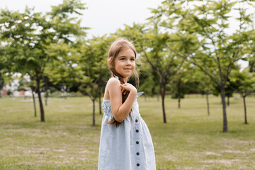 Happy toddler girl posing and smiling. Portrait of adorable child in the park.