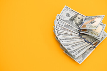 Top view of bundle of 100 dollar bill on yellow background. Business concept with copy space