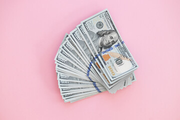 Top view of bundle of 100 dollar bill on pink background. Business concept with copy space
