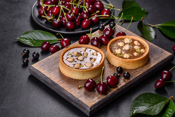 Delicious fresh nougat and nut tart with fresh berries on a wooden cutting board