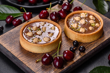 Delicious fresh nougat and nut tart with fresh berries on a wooden cutting board