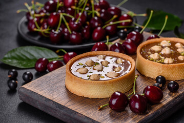 Delicious fresh nougat and nut tart with fresh berries on a wooden cutting board