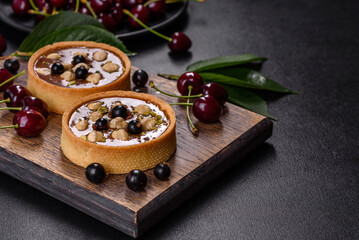 Delicious fresh nougat and nut tart with fresh berries on a wooden cutting board