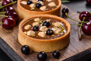 Delicious fresh nougat and nut tart with fresh berries on a wooden cutting board