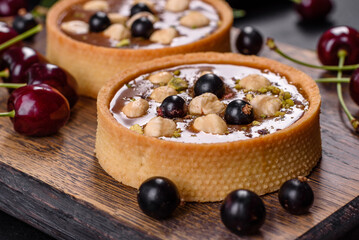 Delicious fresh nougat and nut tart with fresh berries on a wooden cutting board