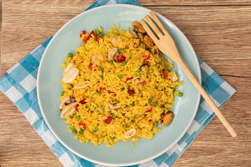 Arroz amarillo con pescado y vegetales, visto desde arriba