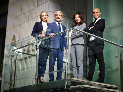 team of multiethnic business men and women standing inside a modern office building