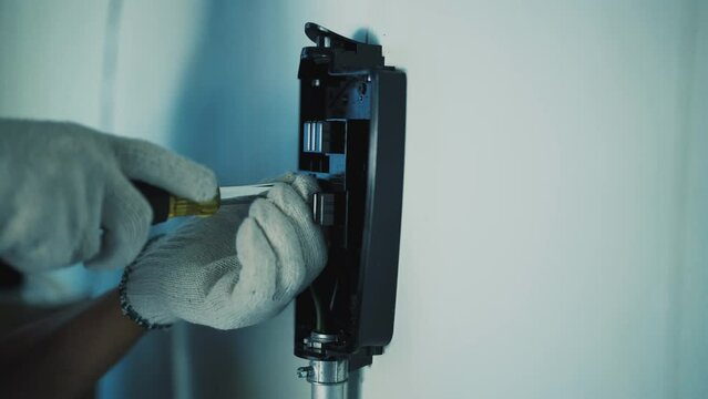 A Man's Hand Screwing the Charging Base. Wall Charger Installation. Upgrade at Home. Technology Concept