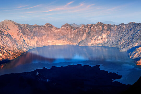 Lake in the crater of a volcano at sunset. Reflection of water. Indonesia. Rinjani volcano. © delbars