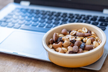 Side view, container with nuts on laptop