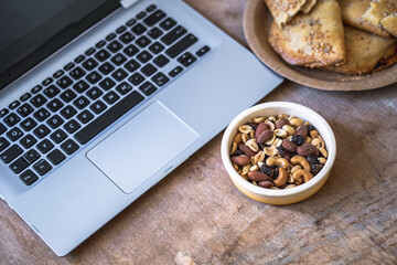 Side view, container with nuts on laptop