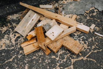 Background, texture of sawn wooden boards, bars with sawdust after a sawmill on asphalt. - obrazy, fototapety, plakaty