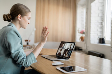 A woman with glasses works, uses video communication, makes a report to the company on finances
