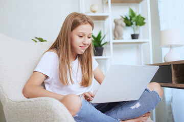 Young girl working at home on a laptop, online training