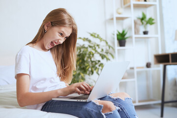 Young girl working at home on a laptop, online training
