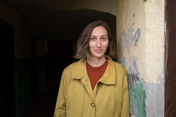 young caucasian smiling woman with short hair standing alone at corridor