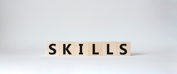 Skills symbol. Concept word Skills on wooden cubes. Beautiful white background. Business and Skills concept. Copy space.