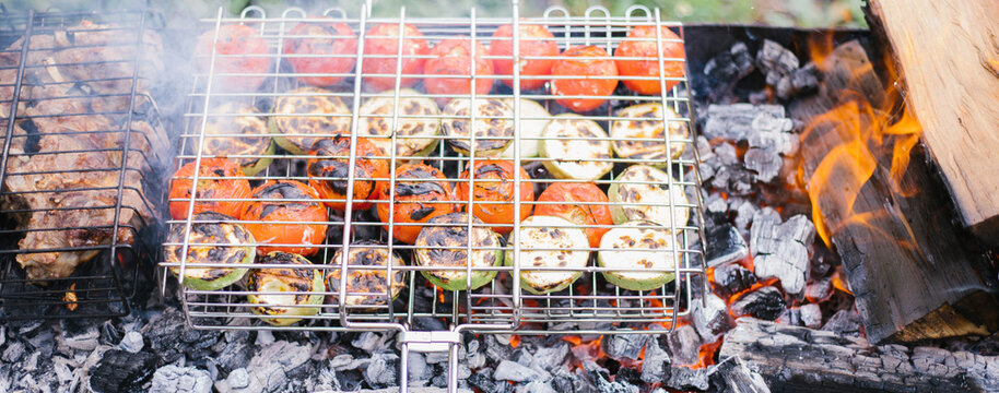Summer snack, colorful barbecue vegetables, tomatoes and zucchini. Delicious healthy food for a large company of people. Picnic in nature.