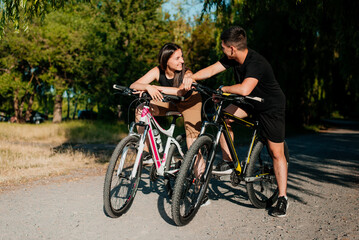 Young couple ride bicycles in the park.