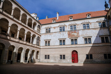 Fototapeta na wymiar Litomysl, Czech Republic, 17 April 2022: Renaissance aristocratic castle, UNESCO World Heritage Site, chateau with sgraffito mural decorated plaster at facade at sunny day, courtyard with arcades