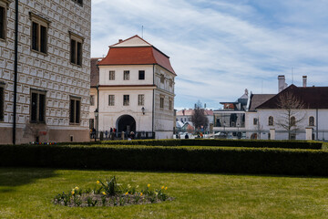 Fototapeta na wymiar Litomysl, Czech Republic, 17 April 2022: Renaissance castle, UNESCO World Heritage Site, chateau with sgraffito mural decorated plaster at facade at sunny day, medieval historical town with park