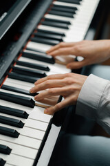 refined woman pianist plays the piano with thin fingers, sensually plays a musical instrument