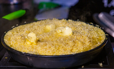 close-up of buttered rice cooked in an earthenware casserole and selective focus