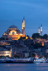 Suleymaniye Mosque with night illumination and minaret of Rustem Pasha Mosque, Istanbul, Turkey