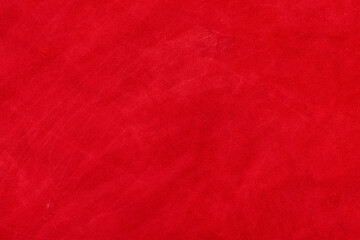 Red suede genuine leather background. Velvet red background close-up photo.