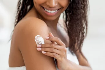 Foto op Plexiglas Closeup Shot Of Young Black Female Rubbing Moisturising Lotion To Skin © Prostock-studio