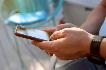 Man is checking something on his  smartphone outside.