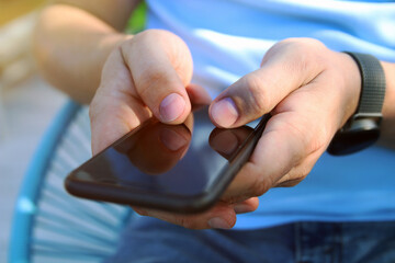 Man is checking something on his  smartphone outside.