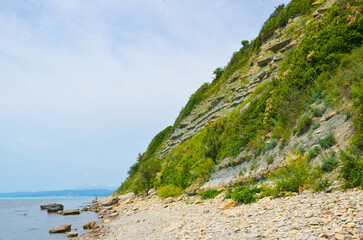 The seashore near the rocks are stones on the shore. Selective focus.