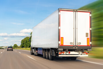 White blank modern delivery big shipment cargo commercial semi trailer truck moving fast on motorway road city urban suburb. Business distribution logistics service. Lorry driving highway sunny day