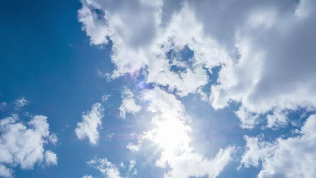 Bright sunlight shines through white fluffy clouds in sunny cloudy day. timelapse 4k resolution of cloudscape natural background. summer season hot weather forecasting footage. outdoor scenic blue sky