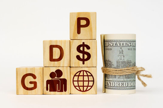On a white surface, dollars and cubes with images and the inscription - GDP