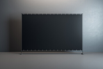 Front view on blank black billboard with space for your text or logo in the center of empty room with glossy floor and dark concrete wall background. 3D rendering, mockup