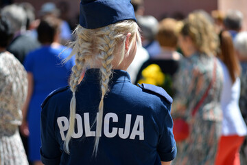 Młoda policjantka blondynka w mundurze na służbie w mieście.