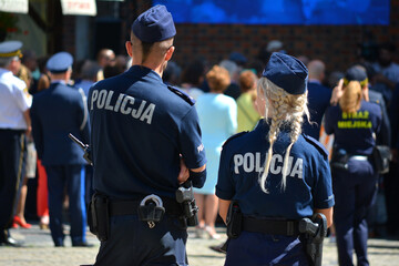 Młoda policjantka blondynka w mundurze na służbie w mieście.