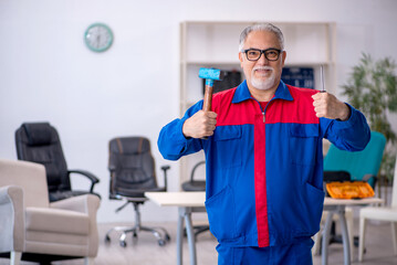 Old male repairman working at workshop