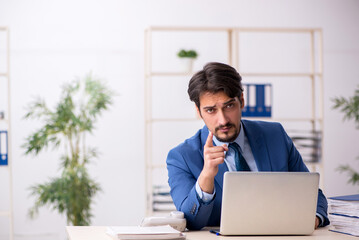 Young male employee and too much work in the office