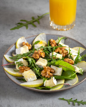 salad with pear, cheese with mold, arugula and walnuts with orange juice