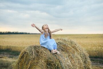 Naklejka na ściany i meble Girl in a wheat field on a barley