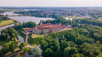 Fototapeta na wymiar Aerial view of Nesvizh Castle and river, Belarus. Medieval castle and palace. Restored medieval fortress.