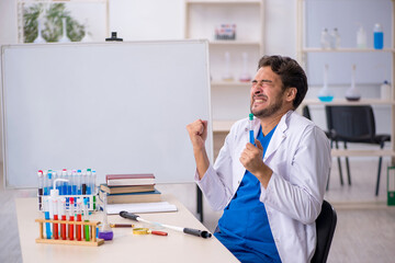 Young male chemist working at the lab