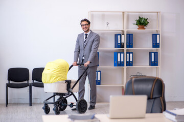 Young male employee looking after new born at workplace