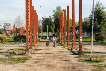 woman walking her pet in the park on a sunny day