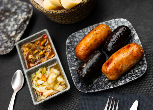 Delicious Uruguayan parrillas of chorizo and morcilla sausages served with spicy vegetable salsa criolla of tomatoes, onion and herbs..