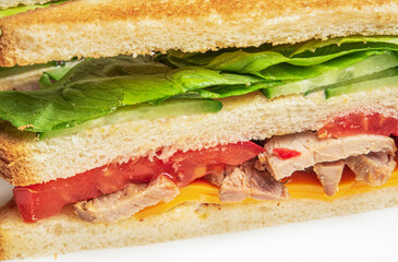Sandwich with ham and vegetables. Sandwich background, Layers of a sandwich with cheese, lettuce, meat, tomatoes and cucumbers.
